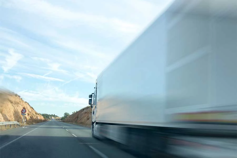 White truck driving on an empty road