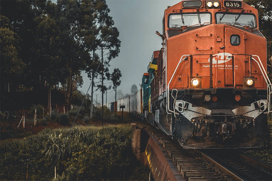 Orange train on railway with containers